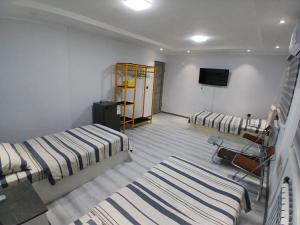 a room with two beds and a tv in it at Guest House "Markaz" in Khorog
