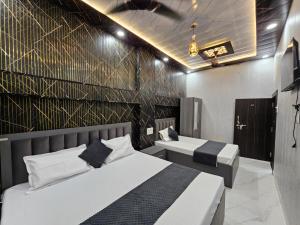 a bedroom with two beds and a wall at Royal Rani Residency in Ayodhya