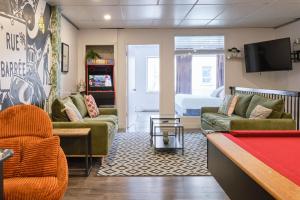 a living room with couches and a pool table at MtlVacationRentals - The Entertainer in Montreal