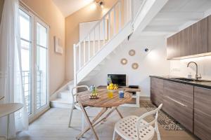 a kitchen with a table and chairs and a staircase at VILLA CARLA appartement central zone piétonne clim in Menton