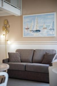 a couch in a living room with a painting of sailboats at VILLA CARLA appartement central zone piétonne clim in Menton