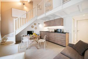 a living room with a table and a kitchen with a staircase at VILLA CARLA appartement central zone piétonne clim in Menton