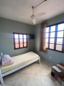 a bed in a room with two windows at Casa Salinas em Salinópolis PA - Completa in Salinópolis +16 photos