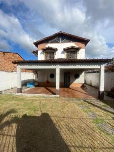 a white house with two windows and a yard at Casa Salinas em Salinópolis PA - Completa in Salinópolis