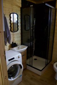 a bathroom with a washing machine and a sink at By The Lake - Domki I Sauna Nad Jeziorem in Załęże +71 photos