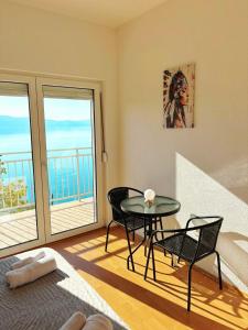 a room with a table and chairs and a balcony at Indijano Apartment in Ohrid +2 photos