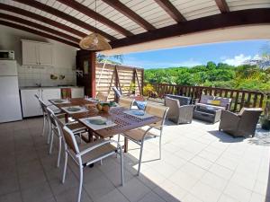 a dining room with a table and chairs on a patio at Ti Village Creole in Sainte-Anne