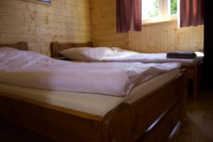 two twin beds in a room with a window at By The Lake - Domki I Sauna Nad Jeziorem in Załęże