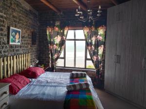 a bedroom with a bed and a window with flowers at Vinknes in Boknes