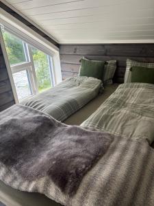 two beds sitting in a room with a window at VillaElvesus in Vossevangen