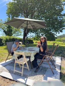 a woman sitting at a table under an umbrella at Casa Mirabel Laurel in Fene +48 photos