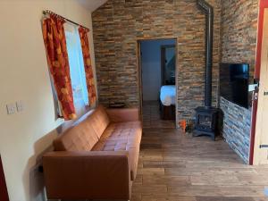 a living room with a couch and a fireplace at Glan Llyn Farm House in Mold