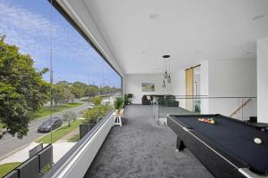 an empty living room with a pool table and large windows at Urban Hideaway - Stay 4 Pay 3 in Gold Coast