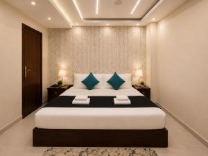 a bedroom with a large bed with blue pillows at Oyal Scarab Pyramids View in Cairo