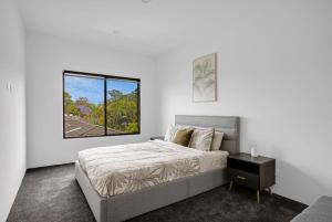 a white bedroom with a bed and a window at Urban Hideaway - Stay 4 Pay 3 in Gold Coast +32 photos