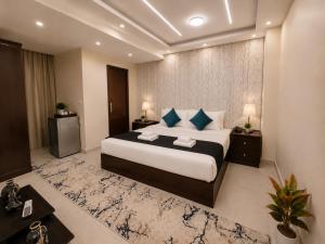 a bedroom with a large bed with blue pillows at Oyal Scarab Pyramids View in Cairo +71 photos