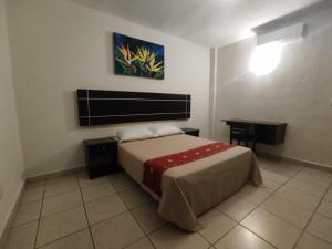 a bedroom with a bed and a table in it at Urbania Office Hotel in Tuxtla Gutiérrez