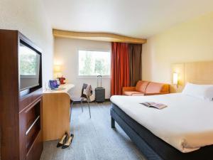 a hotel room with a bed and a desk at ibis Metz Nord in Woippy +136 photos