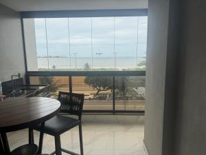 a room with a table and chairs and a large window at Apartamento del sole in Vitória