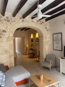 a living room with a stone wall and a ceiling fan at Campet50 in Felanitx