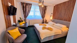 a hotel room with a bed and a chair at Penzión Blanka in Ždiar