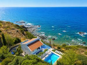 a house with a swimming pool next to the ocean at Panorama Villa in Pomos
