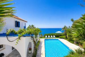a villa with a swimming pool and the ocean at Panorama Villa in Pomos