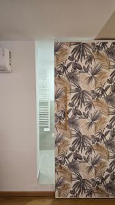 a room with a wall with a mural of leaves at Tiny House in Quarto dʼAltino