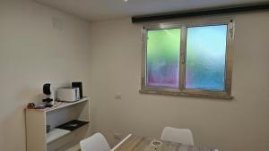 a room with a window and a table and chairs at Tiny House in Quarto dʼAltino +4 photos