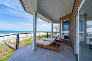 a balcony with a bed and a view of the ocean at Seaview Serenity - Team Joseph Ellen in Jacksonville Beach