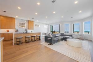 a kitchen and living room with a couch and a table at Seaview Serenity - Team Joseph Ellen in Jacksonville Beach