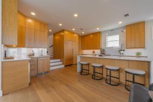 a large kitchen with wooden cabinets and bar stools at Seaview Serenity - Team Joseph Ellen in Jacksonville Beach +57 photos