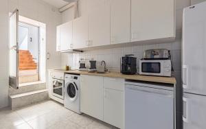 a kitchen with white cabinets and a washer and dryer at Casa Marina - Desayuno y parking incluidos in Portman +27 photos