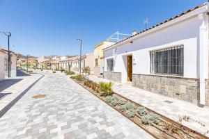 a cobblestone street in front of a white building at Casa Marina - Desayuno y parking incluidos in Portman
