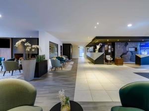 a lobby of a hotel with chairs and tables at Mercure Aachen Europaplatz in Aachen