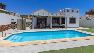a swimming pool in front of a house at Villa with private pool, near beach and golf Caleta de Fuste- Villa Charlotte in Costa de Antigua +47 photos