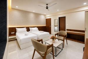 a hotel room with a bed and a table and chairs at The Sapphire Hotel in Belgaum +71 photos