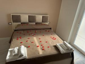 a bed with red poppies on it with towels and flowers at Hotel Doc in Vairano Scalo +12 photos