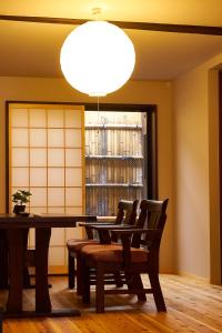 une salle à manger avec une table, des chaises et un éclairage dans l'établissement Kyoyado Hakuto, à Kyoto