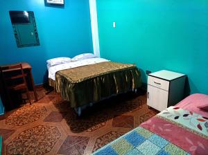 a bedroom with two beds and a blue wall at Hospedaje LA RESIDENCIA in Ayacucho +4 photos