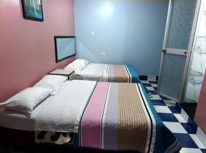 a bedroom with two beds in a room at Hospedaje LA RESIDENCIA in Ayacucho