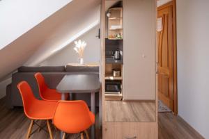 a room with a dining table and orange chairs at Nida Inn Self Check-in in Nida