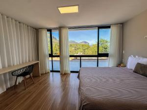 a bedroom with a bed and a desk and a window at Casa do Valle Hotel Boutique - Vale do Capão in Vale do Capao +63 photos