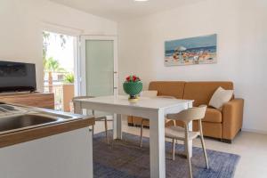 a kitchen and living room with a table and a couch at Sea Residence LUNA ROSSA in Marzamemi
