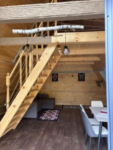 a wooden staircase in a room with a table and chairs at Complex turistic Casa Diaconu in Breaza