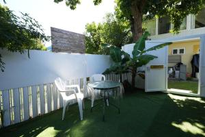 a patio with two chairs and a table and a fence at Libertas in Pointe d'Esny