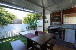 a patio with a wooden table and a kitchen at Libertas in Pointe d'Esny