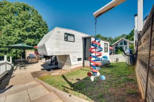 a small white tiny house with a playground at Pool & Dock Access! Badin Lake Resort Gem in New London