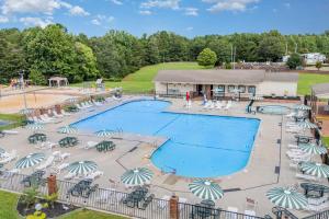 a large swimming pool with chairs and umbrellas at Pool & Dock Access! Badin Lake Resort Gem in New London