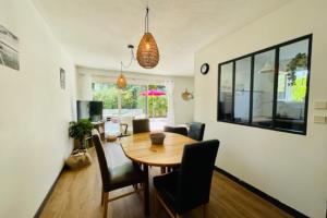 a dining room with a wooden table and chairs at Spacious cocoon with pool in La Rochelle in La Rochelle